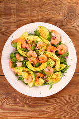 Shrimp salad with avocado arugula, scallion and almonds. View from above, top studio shot, vertical