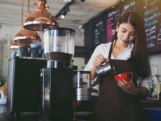Portrait of barista woman making coffee.