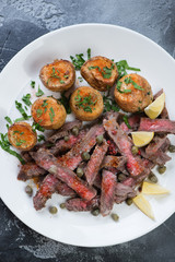 Top view of grilled tagliata steak with baked potatoes, vertical shot