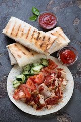 Shaurma or shawarma with roast chicken meat and vegetables wrapped in lavash