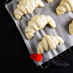 ready for baking croissants on a baking sheet for baking. brush with egg yolk