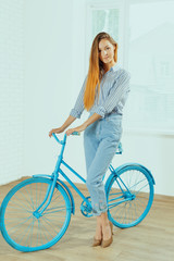 Cheerful young woman standing near bicycle