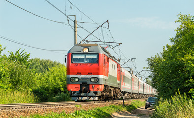 Fototapeta premium Electric locomotive with a passenger train in Russia