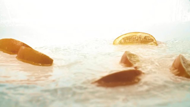 Orange falling into water in slow motion