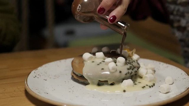 pancakes with white kem are poured with chocolate. dessert with berries and cream