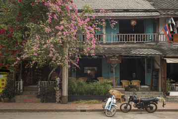Vehicles parked on road outside stores, Luang Prabang, Laos