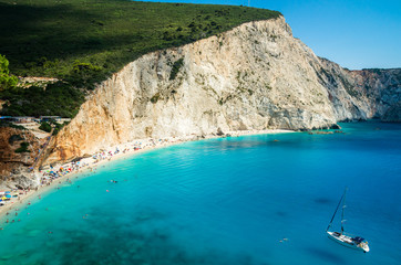 Obraz premium Porto Katsiki beach in Lefkada island, Greece. Beautiful view over the beach. The water is turquoise and there are tourists on the beach and a boat on the sea.