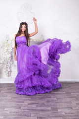 Studio portrait of a smiling beautiful woman throwing her dress