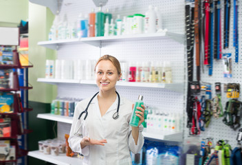 Happy female shop assistant offering shampoo