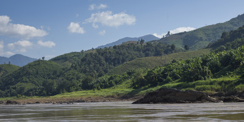 Fototapeta na wymiar Scenic view of river shoreline with mountain range in background, River Mekong, Sainyabuli Province, Laos