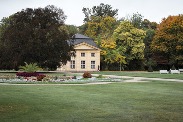 classic garden house by trees against cloudy sky