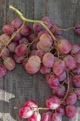 A bunch of red grape on an old wooden board.