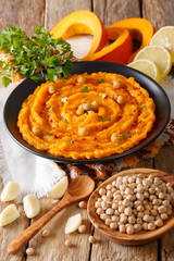 Middle Eastern food: pumpkin hummus with ingredients close-up. vertical