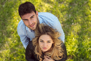 Fototapeta premium Top view. cheerful couple, standing barefoot in the grass looking at camera.
