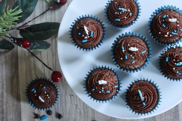 Mini Frosted Chocolate cupcakes on Christmas Holiday background