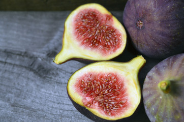 Fresh ripe fig fruits on old wooden background.Whole and sliced figs.Selective focus. 