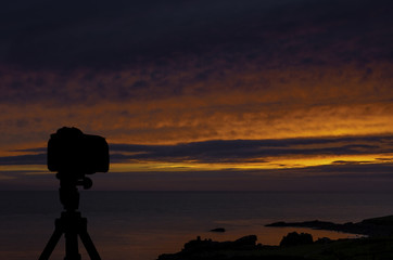Camera on tripod with ocean and sunset in background / St Ives / Cornwall / United Kingdom