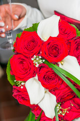 Brautstrauß mit Rosen und Callas getragen von der Braut