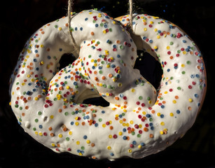 Bright colorful pretzel covered with sweet glaze and sprinkled