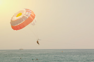 Man is flying on a paraglider over the sea. Toned