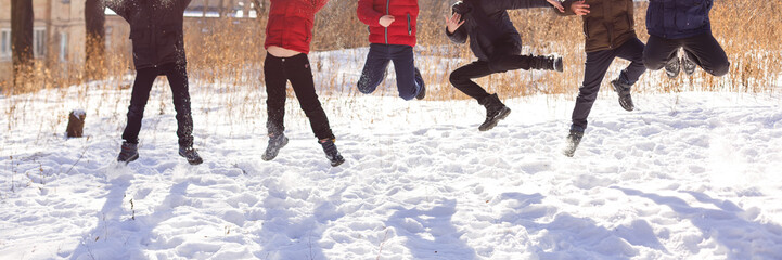 Fototapeta na wymiar Group of cheerful children jumping in the snow in winter