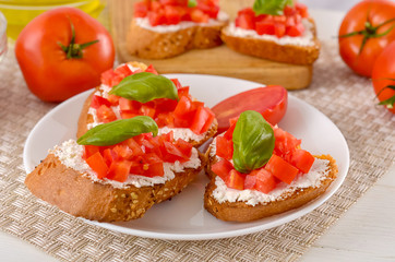 Fototapeta na wymiar delicious bruschetta with tomatoes on plate on table close-up