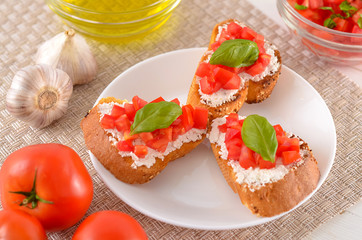 delicious bruschetta with tomatoes on plate on table close-up