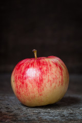 Red and yellow apple on old wooden background