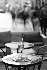 A glass with a cocktail and a light snack on the table of a street cafe