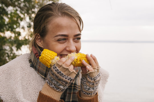 Portrait of girl eating boiled corn in the nature