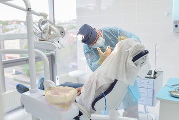 Dental surgery operation in modern dentist clinic, surgeon doing injection to patient
