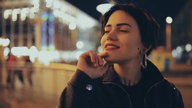 Slowmotion of young pretty woman in city street enjoying a nighttime life