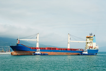 Side view of industrial cargo ship floating on water of sea in calm day.