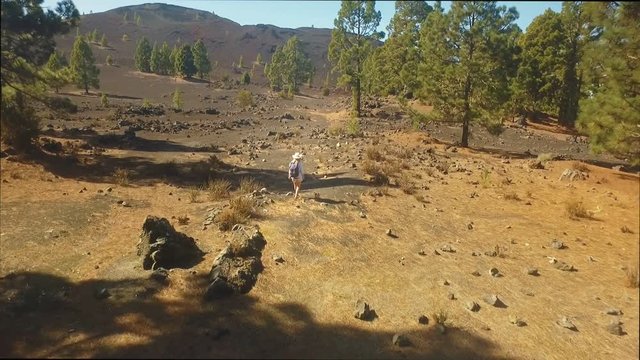 girl with a backpack on the path on the way to the crater of the volcano