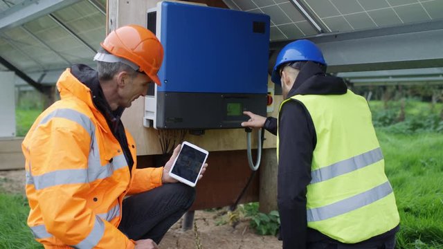  Technicians checking the electricity box at solar energy installation