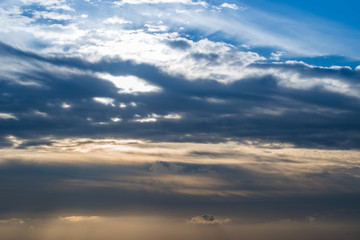 Himmel mit Sonnenlicht und Wolken am Abend, blaue und orange-gelbe Farben