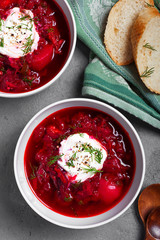 Red hot borch beetroot soup with sour cream. A traditional russian soup. Top view. Fall dinner and lunch. Grey background