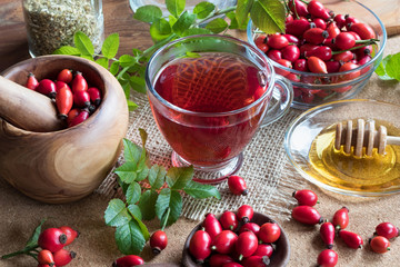 A cup of rose hip tea with fresh rose hips