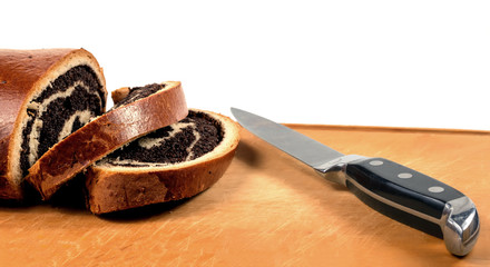 Poppy seed strudel and a knife on a cutting board..Selective focus..