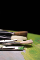 Artistic brushes with traces of paint on a dark background. Back to school. Paintings Art Concept. Selective focus. Copy space.
