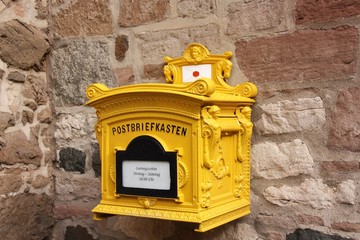 Old yellow German Mailbox hanging on a wall