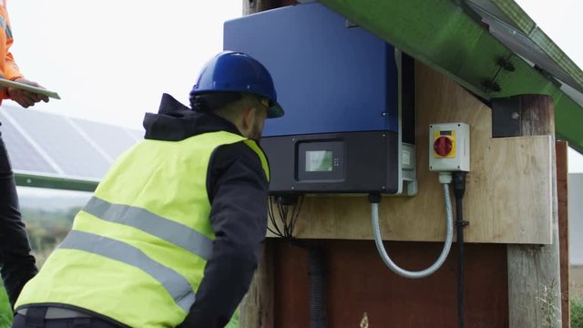  Technicians checking the electricity box at solar energy installation