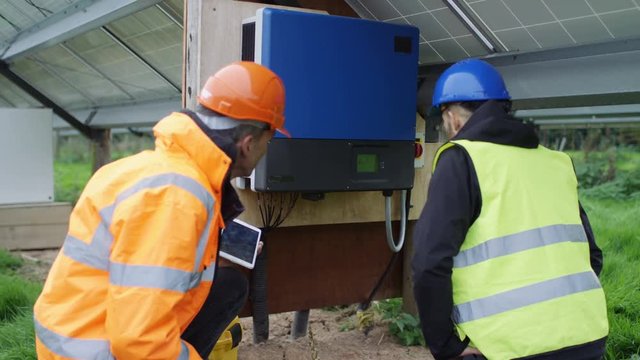  Technicians checking the electricity box at solar energy installation