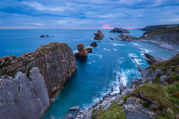 The rocks of Arnia beach in Cantabria during a sunrise