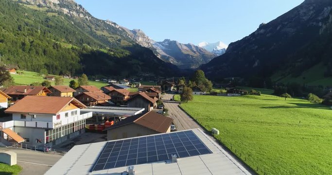 Aerial view of traditional small cottages with solar cell panels on the roof. Scenic alpine mountain landscape top view