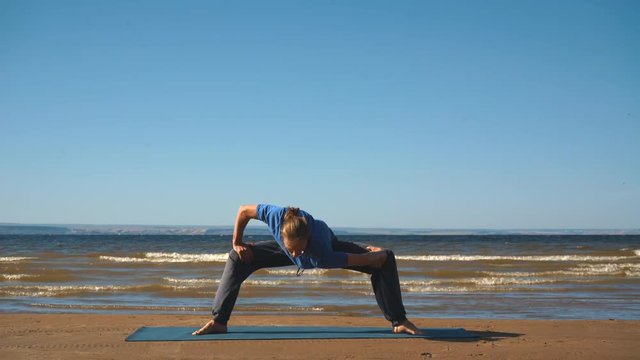 Athletic muscular young man working out, yoga, goddess, sumo wrestler pose