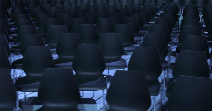 large Empty conference hall with rows of seats for spectators and audience.