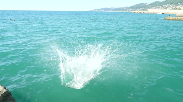 the man dives off the pier in the sea. 4k, slow motion
