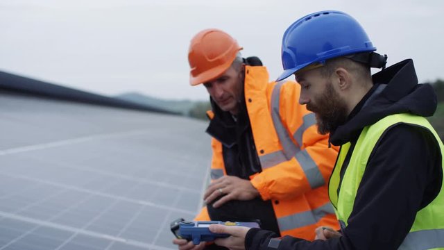  Technicians checking the panels at solar energy installation