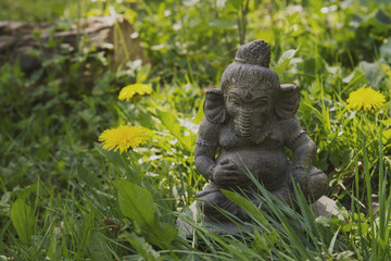 Fototapeta na wymiar ganesha stone statue in a green garden